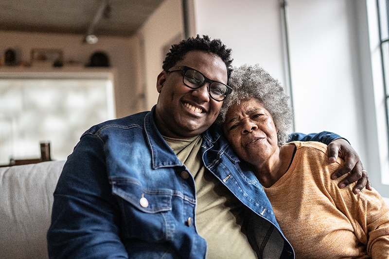 Portrait of mother and son embracing in the living room at home